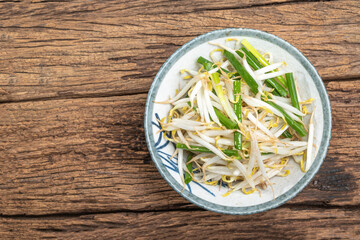 Healthy vegetarian food fried bean sprout in bowl on wood table.