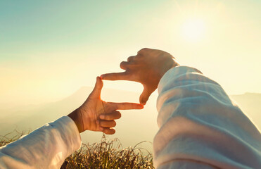woman hand framing looking view sunrise