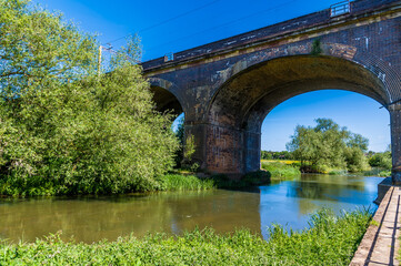 Fototapeta na wymiar A view down the river Great Ouse towards the fourteen arches viaduct at Wolverton, UK in summertime