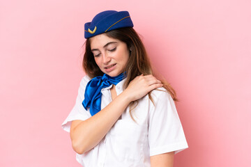 Airplane stewardess caucasian woman isolated on pink background suffering from pain in shoulder for having made an effort