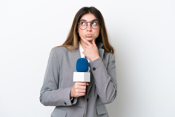 Fototapeta premium Young caucasian TV presenter woman isolated on white background having doubts