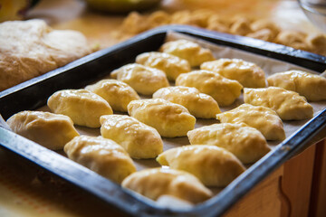 Homemade pies on a baking sheet before cooking in the oven