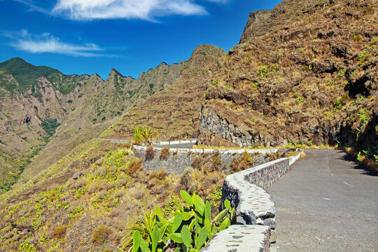 Idyllic narrow curvy empty mountain serpentine pass road through rough mountain range on canary islands along steep slope, La Gomera