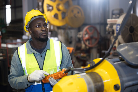 Black Engineer Worker Use a Remote Control to Control the Overhead Crane