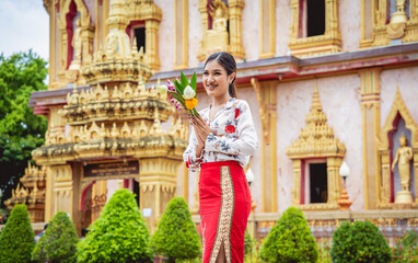 Obraz premium Beautiful Asian girl at big Buddhist temple dressed in traditional costume