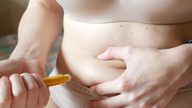 Female makes injection in stomach, belly or abdomen. IVF in vitro fertilisation, reproductive infertility, sterility treatment. Hormonal drugs, ovulation stimulation. Woman injecting insulin, diabetes