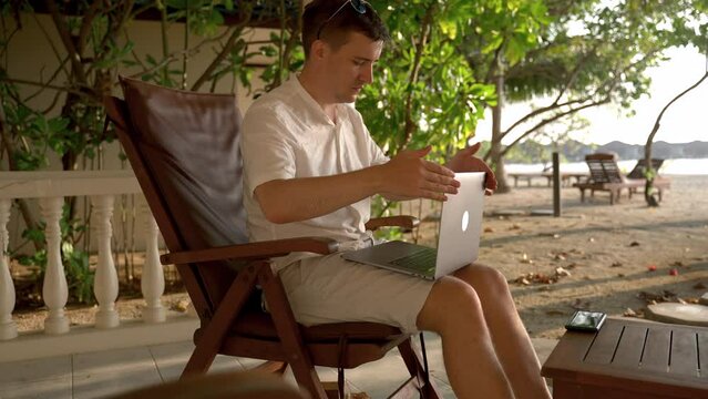 Man happy of workday ending on vacation at tropical island. Caucasian man closes laptop puts on sunglasses and start to rest and relax.