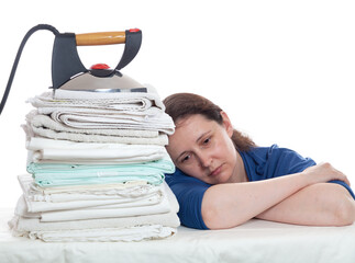 Tired woman sitting near a pile of unironed linen....