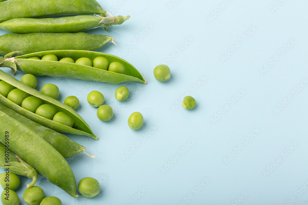 Wall mural fresh green peas on blue background. flat lay. top view