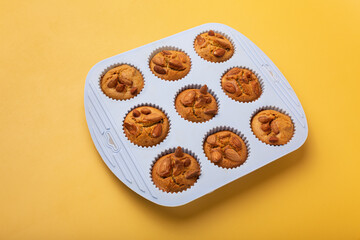 overhead view cupcake danish almond served on white plated ceramic dish isolated on yellow pastel background with clipping path