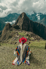 Photograph of a tourist woman in Machu Picchu. Traveler with poncho and Inca hat. Wonder of the World. Colors