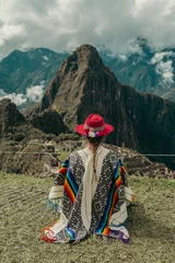Papier Peint photo Machu Picchu Photograph of a tourist woman in Machu Picchu. Traveler with poncho and Inca hat. Wonder of the World. Colors