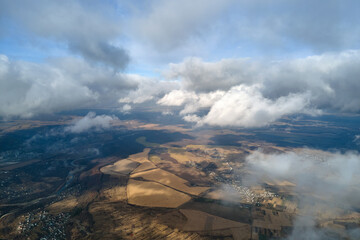 Aerial view from high altitude of earth covered with puffy rainy clouds forming before rainstorm