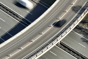 Aerial view of highway road intersection with fast moving heavy traffic. Intercity transportation with many cars and trucks