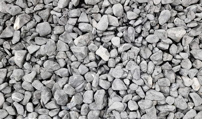 background made of a close up of a pile of crushed stone. grungy pebble stones for exterior flooring covering use as background. pile of small loose decorative garden path stones.
