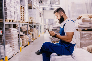 A storage worker checking on shipment on the tablet.