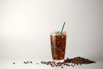 Iced americano coffee with coffee beans on grey background, Glass of black coffee, Beverage at...