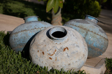 Nice detail in a garden, three antique rusty amphoras