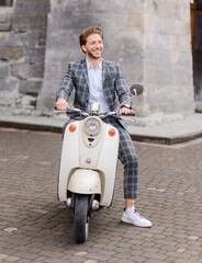 Happy groom posing on scooter