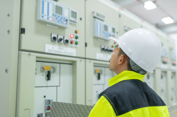 Electrical engineer man checking voltage at the Power Distribution Cabinet in the control room,preventive maintenance Yearly,Thailand Electrician working at company
