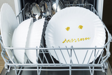 poorly washed dishes in the dishwasher. broken dishwasher. frustrated emotion is depicted on the...