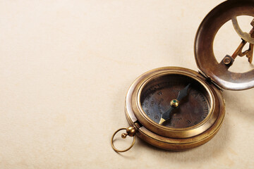Vintage compass with sundial on old paper background.
