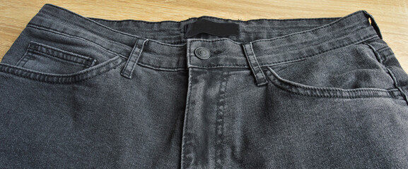 Zipper pocket and buttons close-up detail of light black jeans - obrazy, fototapety, plakaty