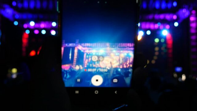 Taking videos and photos with a mobile smartphone at a concert venue