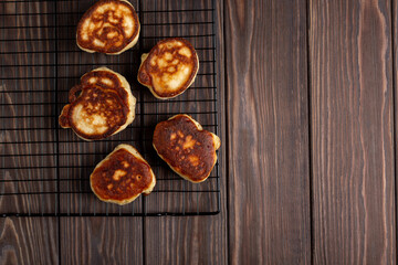 Freshly prepared pancakes cool down on a pastry grill, flat lay, open space