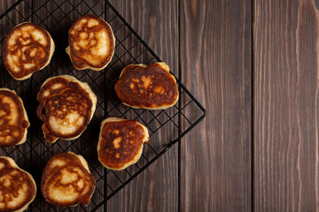 Freshly prepared pancakes cool down on a pastry grill, flat lay, open space