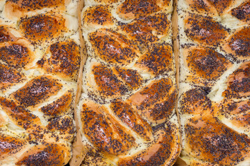 Freshly baked wicker buns with poppy seeds close up. Baking texture, buns top view.Cooking concept.