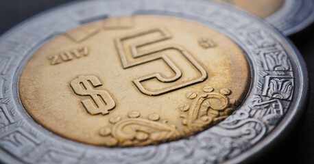 Coin of 5 Mexican pesos closeup. Peso of Mexico. News about economy or currency. Loan and credit. Money and taxes. Focus on peso symbol. Horizontal stories. Macro
