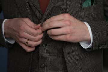 man fastening buttons on his vest