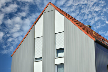 Modernes Wohnhaus mit gemauerten Wänden und Wellblech-Profil Außenverkleidung der oberen Stockwerke