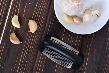 Garlic press and cloves of garlic