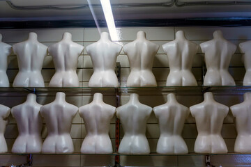 Fototapeta na wymiar Rows of torsos from mannequins are located with their backs without clothes