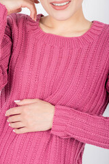 Beauty, fashion and style concept. Woman torso with purple sweater. Beautiful model body shape. Studio shot with copy space. Hand placed on belly with pink manicure