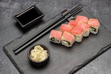 Sushi with tuna and ginger in bowl on stone board.
