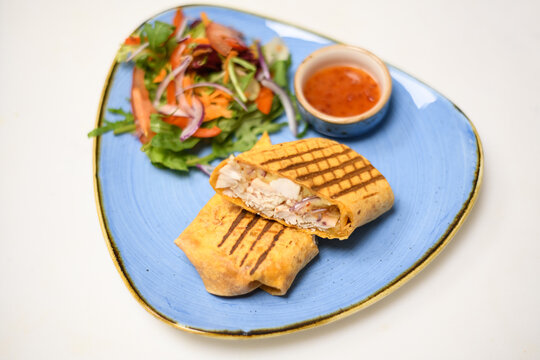 Toasted chicken, cheese and red onion tortilla wrap with salad and chili dip sauce