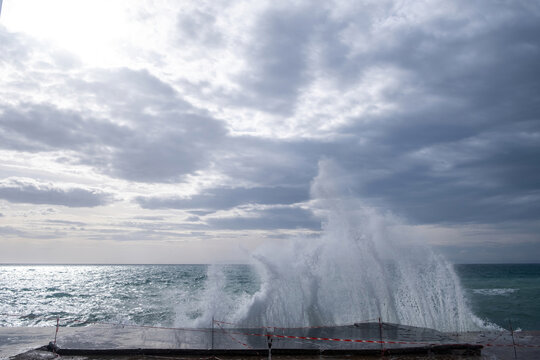 Wave breaking on broken quay concept. Breakwater breakage at pier in wavy Greek blue sea. © Rawf8
