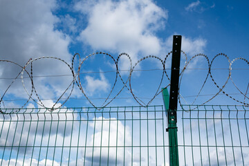 Barbed wire fence with the sky in the background.