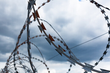 Barbed wire fence with the sky in the background.