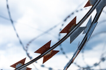 Barbed wire fence with the sky in the background.