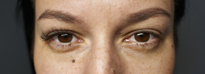female eyes close-up with extended eyelashes. before and after. eyelash extensions for one eye....