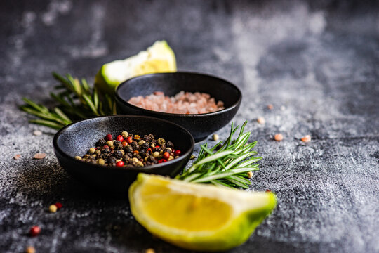 Bowls with pink Himalayan salt, peppercorns, rosemary and lemon slices