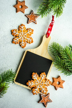 Overhead view of Christmas gingerbread cookies with a blackboard and fir branches