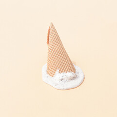 Vanilla ice cream melting on a cream background. Sweet food summer concept for hot summer day. Monochromatic pastel colors.
