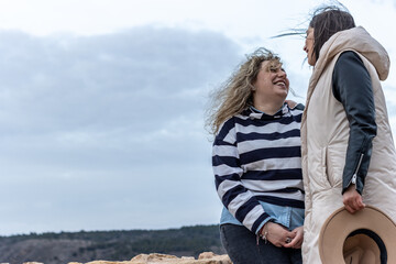 Fototapeta premium A lesbian couple outdoors on a windy day hanging out in nature