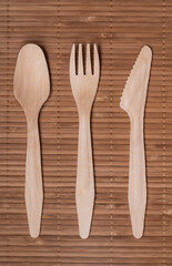 wooden cutlery on bamboo mat