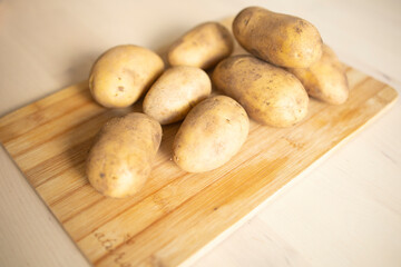 peeled potatoes lie on a wooden table surface, in the kitchen. Potato supply problems, sales restrictions, world hunger